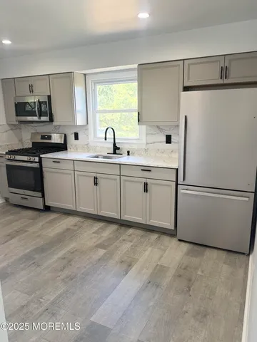a kitchen with white cabinets and white appliances