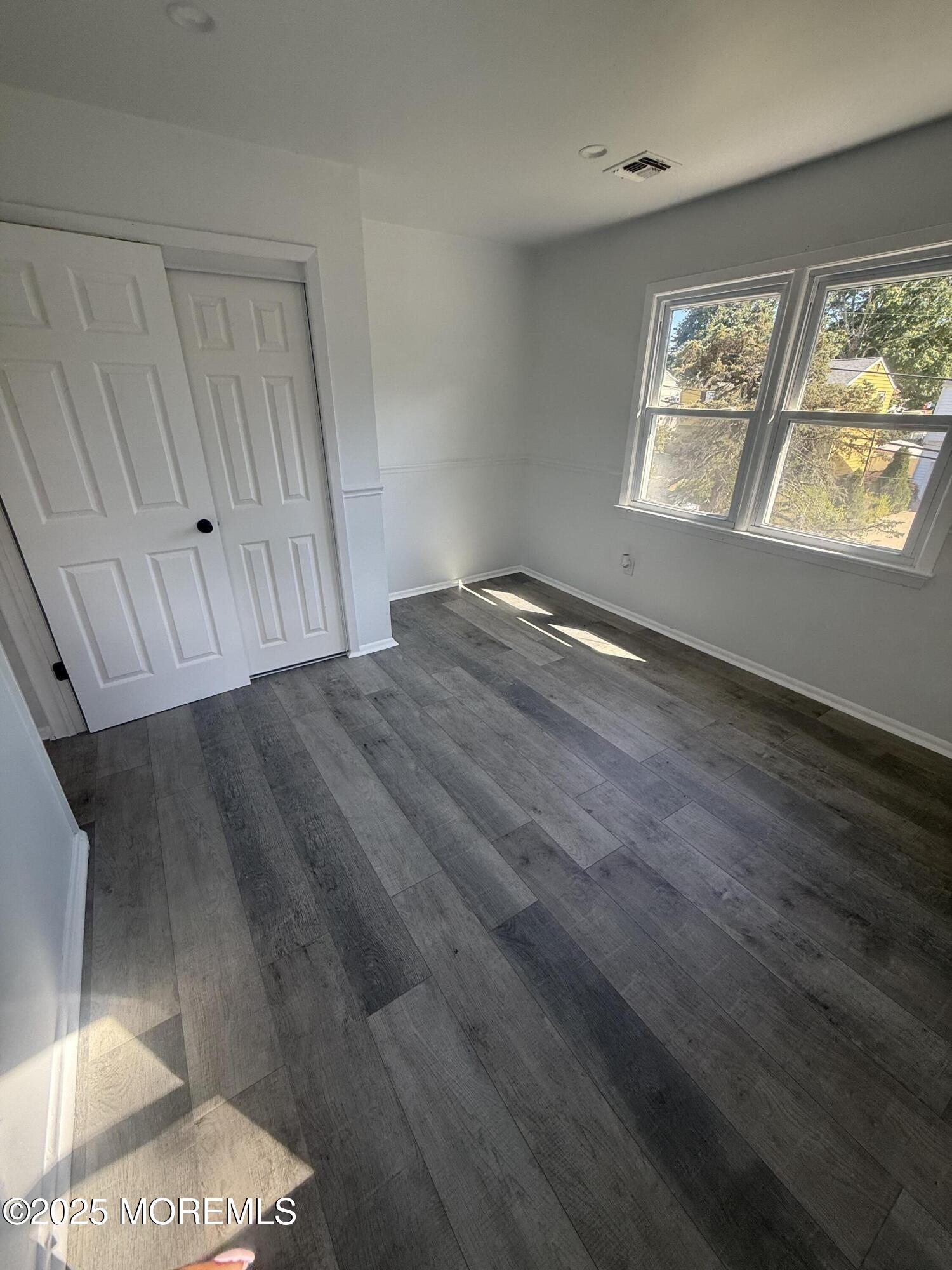 55 Chapin Avenue, Unit 2 Red Bank, NJ 07701 - Photo 10 of 13 a view of an empty room with wooden floor and a window