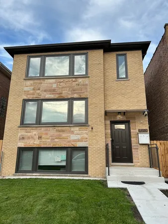 a brick house that has a large windows