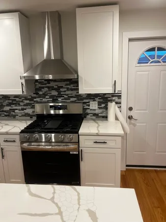 a stove top oven sitting inside of a kitchen