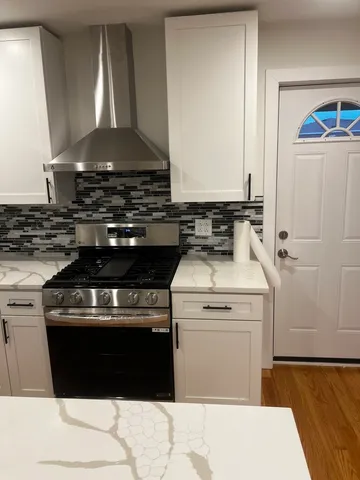 a stove top oven sitting inside of a kitchen