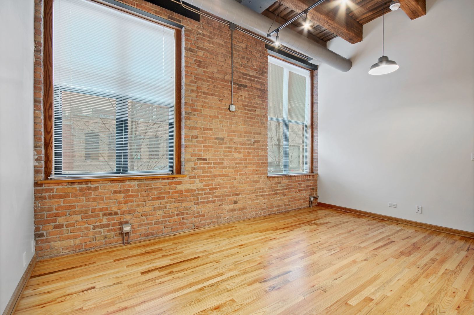 216 North May Street, Unit 101 Chicago, IL 60607 - Photo 16 of 19 a view of an empty room with wooden floor and a window