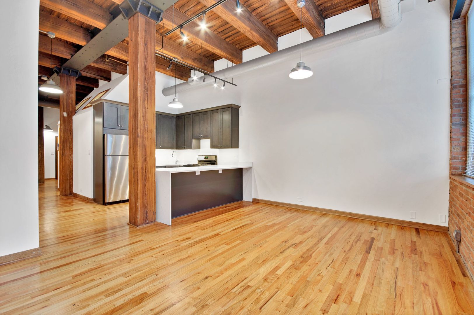 216 North May Street, Unit 101 Chicago, IL 60607 - Photo 2 of 19 a view of kitchen and empty room with wooden floor