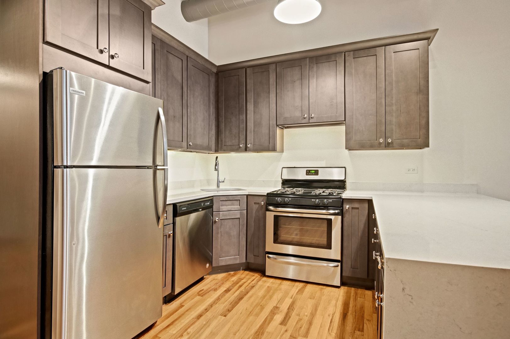 216 North May Street, Unit 101 Chicago, IL 60607 - Photo 7 of 19 a kitchen with a refrigerator stove and wooden cabinets