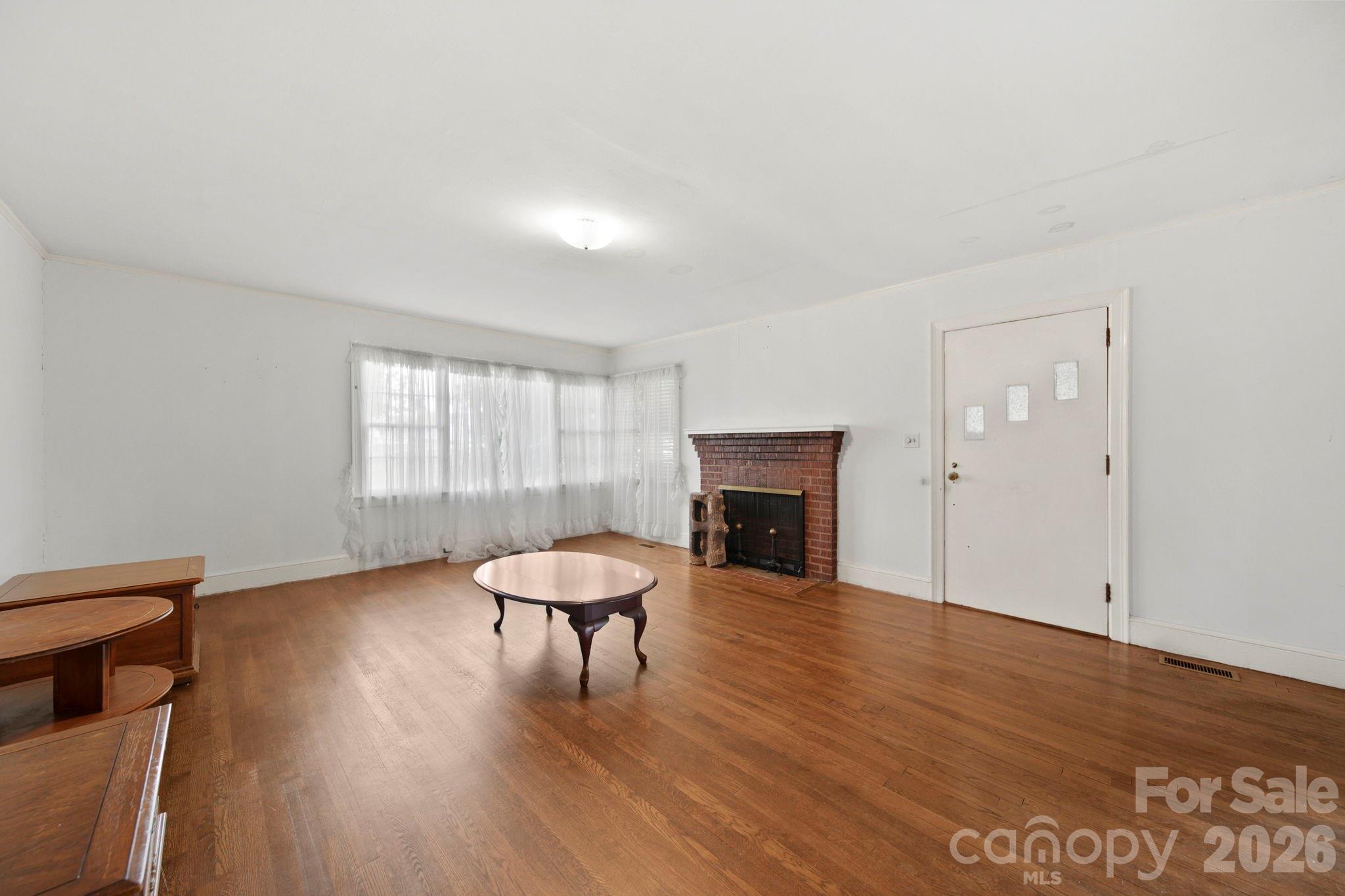1109 Union Road Gastonia, NC 28054 - Photo 6 of 44 a view of an empty room with wooden floor and a window