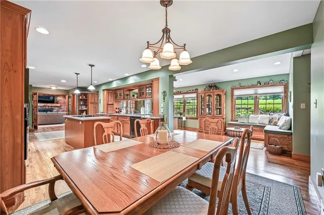 a dining room with wooden floor and large windows