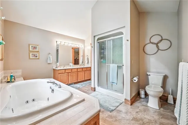 a spacious bathroom with a tub sink mirror and toilet