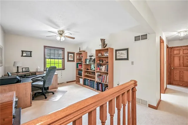 a view of a workspace with furniture and a bookshelf