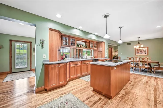 a kitchen with stainless steel appliances granite countertop sink stove and wooden floor