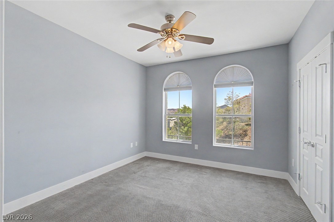 2555 Hampton Road, Unit 6308 Henderson, NV 89052 - Photo 21 of 30 Second Bedroom offers views to east with a cooling ceiling fan and arched windows inviting natural light.