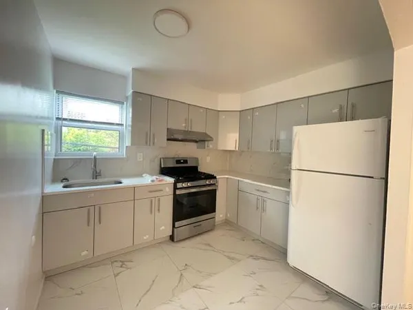 a kitchen with a white stove top oven and refrigerator