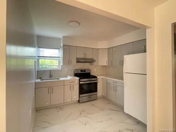a kitchen with a sink a refrigerator and cabinets