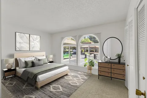 a bedroom with bed and a large window