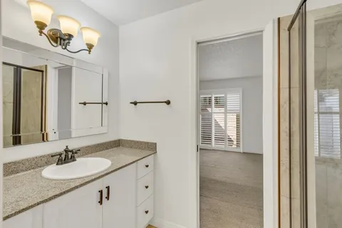 a bathroom with a granite countertop sink and a mirror