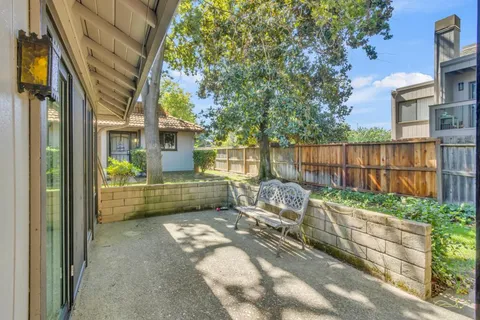a view of house with backyard outdoor seating and wooden fence