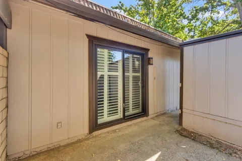 a view of a patio with table and chairs under an umbrella