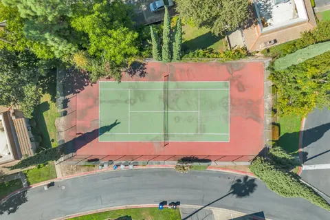 an aerial view of residential houses with outdoor space and trees