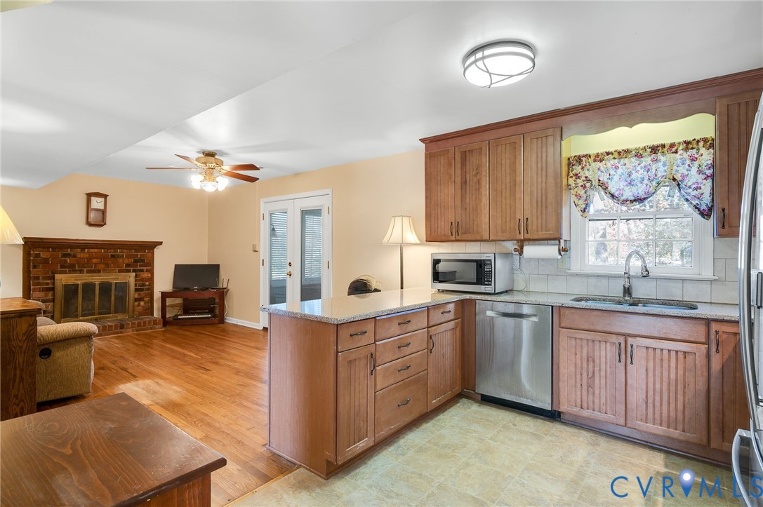 8994 Becton Road Glen Allen, VA 23060 - Photo 11 of 29 Kitchen featuring brown cabinetry, a peninsula, so