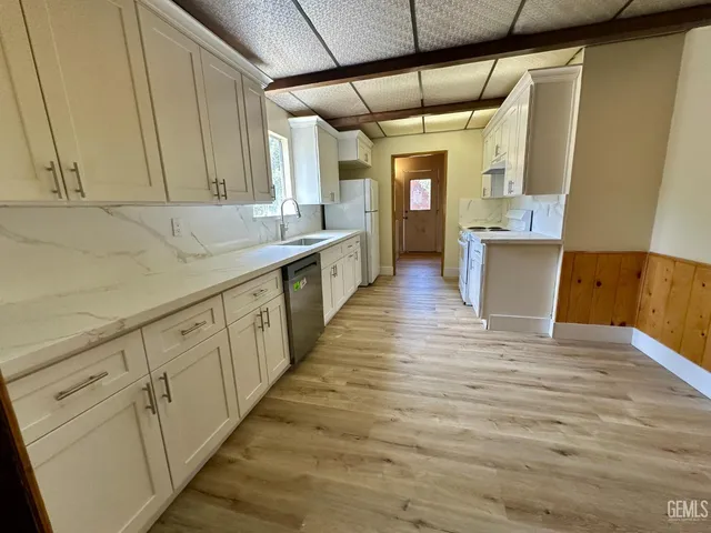 a view of a kitchen with wooden floor and staircase