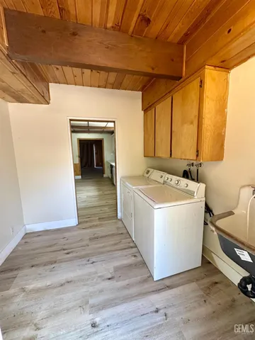 a view of a hallway with wooden floor and furniture