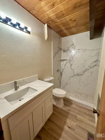 a bathroom with a sink a toilet and shower