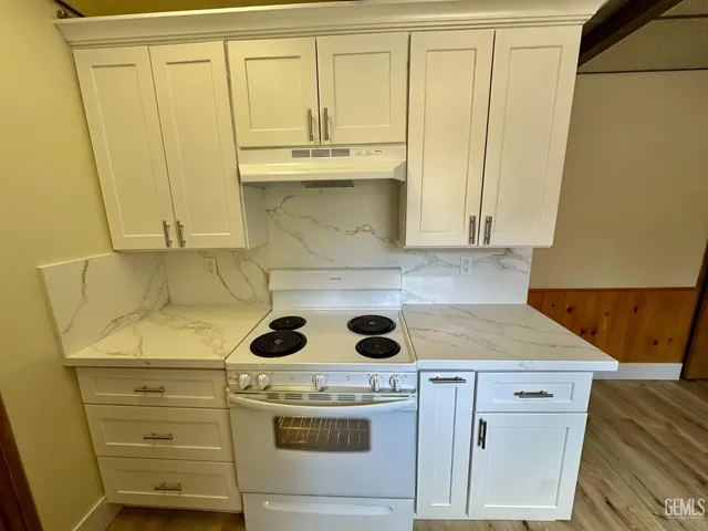 a stove top oven sitting inside of a kitchen