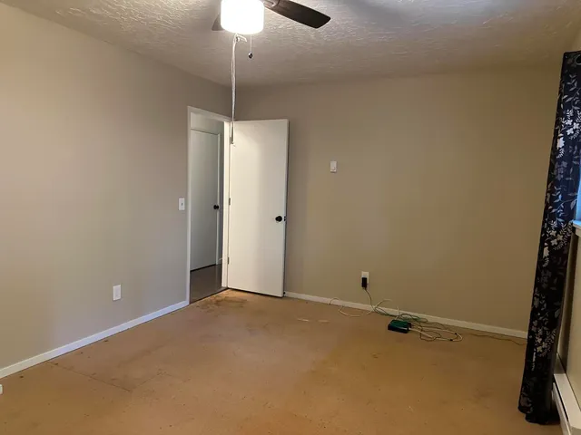 a view of a patio with table and chairs a fire pit and large trees