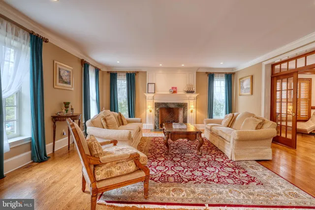 a dining room with wooden floor a chandelier a glass table and chairs