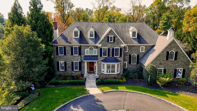 a aerial view of a house next to a big yard and large trees