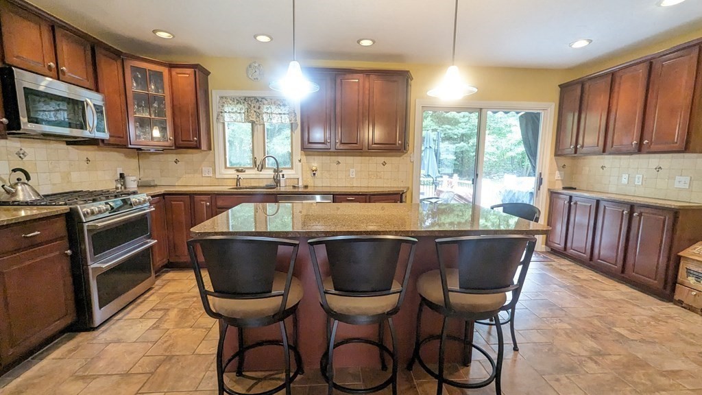 10 Van Gemert Drive Mansfield, MA 02048 - Photo 5 of 33 a kitchen with a table chairs microwave and cabinets
