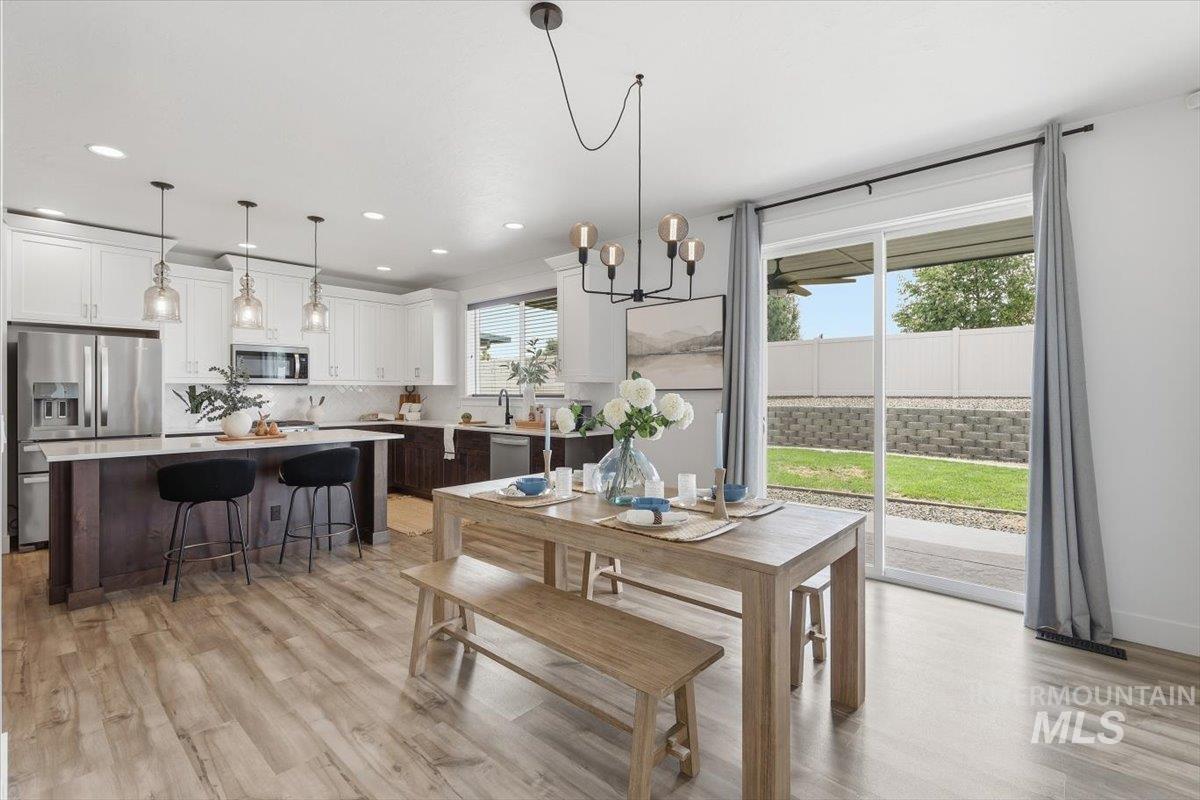 5897 West Riva Capri Street Meridian, ID 83646 - Photo 13 of 50 Open-concept kitchen and dining area featuring light wood-finish flooring