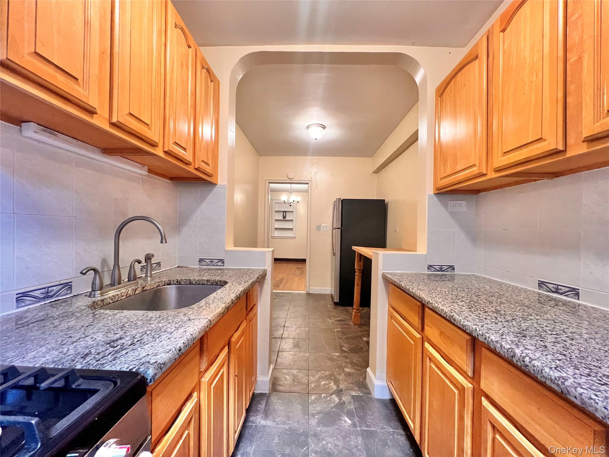 96-11 65th Road, Unit 1 Queens, NY 11374 - Photo 5 of 10 a kitchen with stainless steel appliances granite countertop a sink stove and cabinets