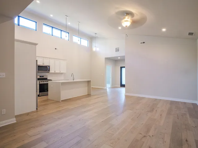 a view of kitchen with kitchen island stainless steel appliances cabinets and wooden floor