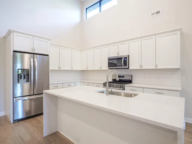 a kitchen with stainless steel appliances a refrigerator stove microwave and sink