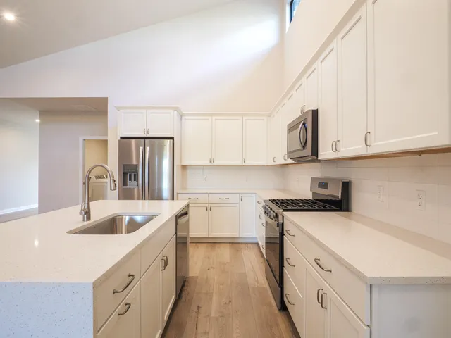 a kitchen with granite countertop white cabinets and white appliances