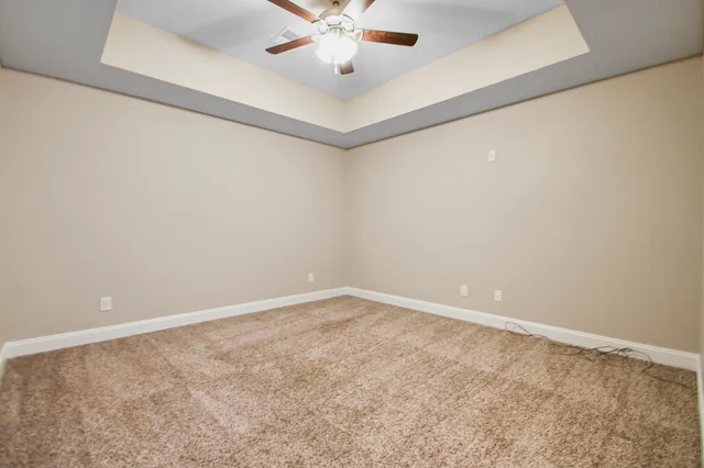 an empty room with a window and a ceiling fan