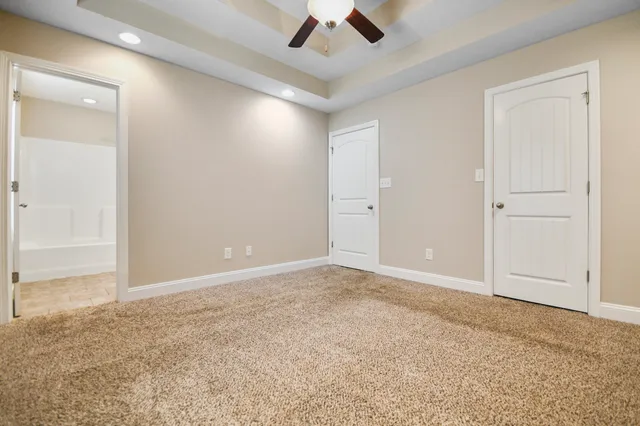 en empty room with an entryway and fan