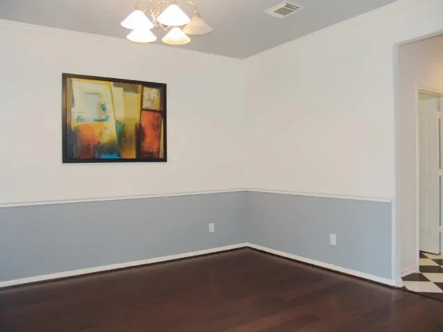 an empty room with wooden floor and window