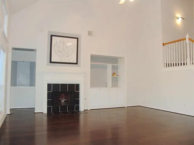 a view of empty room with fireplace and wooden floor