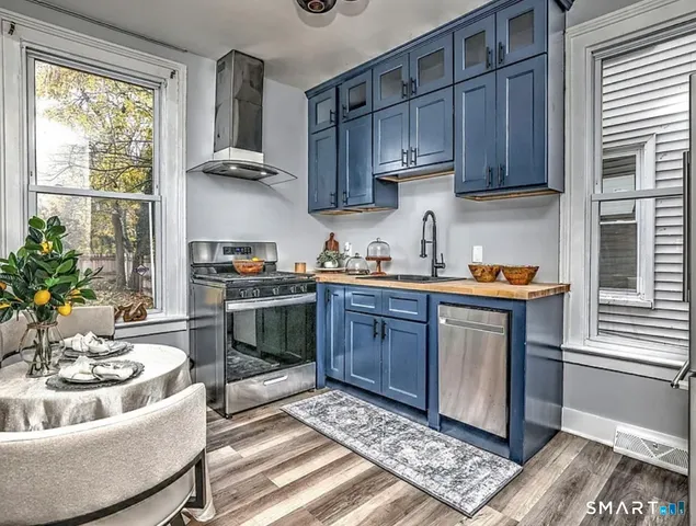 a kitchen with stainless steel appliances granite countertop a sink stove and cabinets