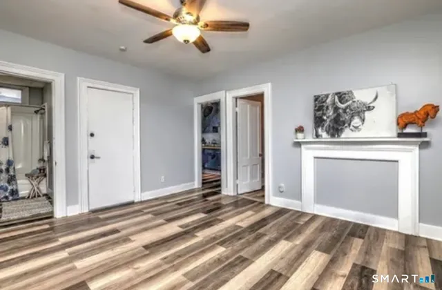 a view of a livingroom with a fireplace and a chandelier fan