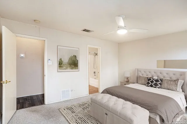 a bedroom with a large bed and a chandelier