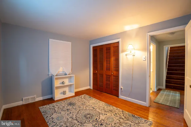 an empty room with closet and wooden floor