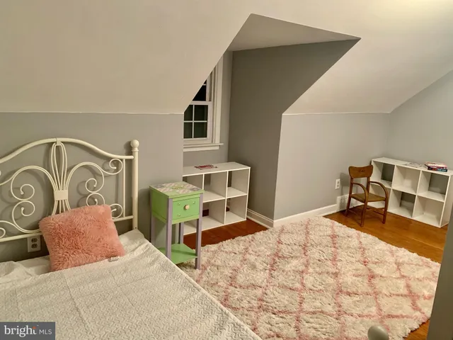 a bedroom with a bed and a flat tv screen on dresser