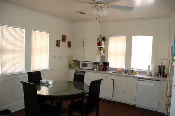 a kitchen with a table chairs sink and cabinets