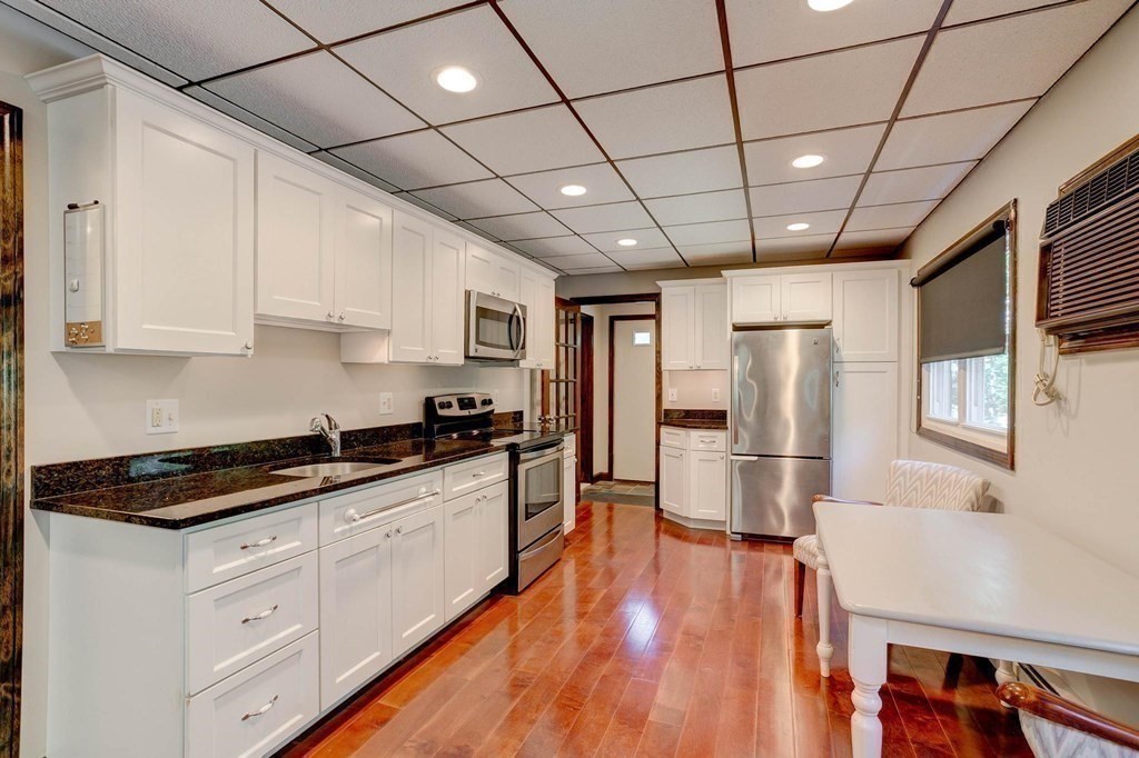 36 Rainbow Circle Peabody, MA 01960 - Photo 18 of 41 a kitchen with stainless steel appliances granite countertop a refrigerator a sink dishwasher a stove and white countertops with wooden floor