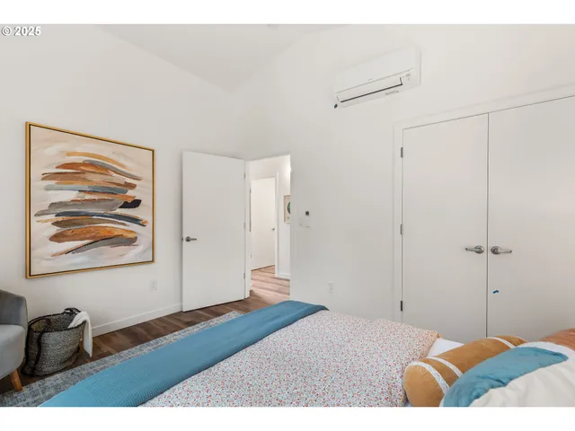 a bedroom with a bed and a painting on the wall