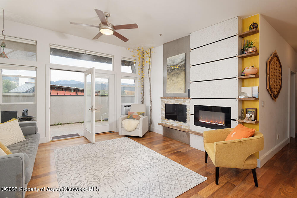 a living room with furniture a fireplace and a table with wooden floor