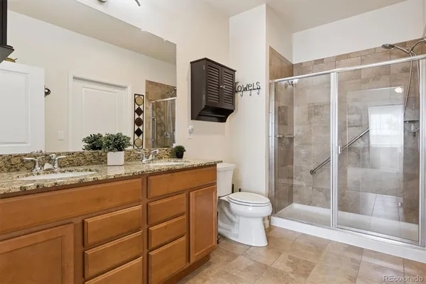 a bathroom with a granite countertop sink toilet and shower