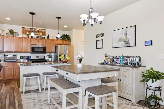 a kitchen with stainless steel appliances kitchen island granite countertop a table and chairs in it